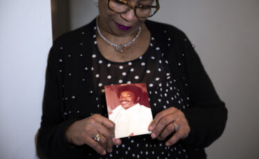 Mary Buffaloe holds a photo of her brother Raymond Michael Caliman at her home in Philadelphia on Wednesday, Nov. 15, 2023. The photo shows Raymond in 1980 on Mary’s wedding day.