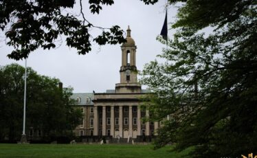 Old Main at Penn State seen through trees on May 9, 2025